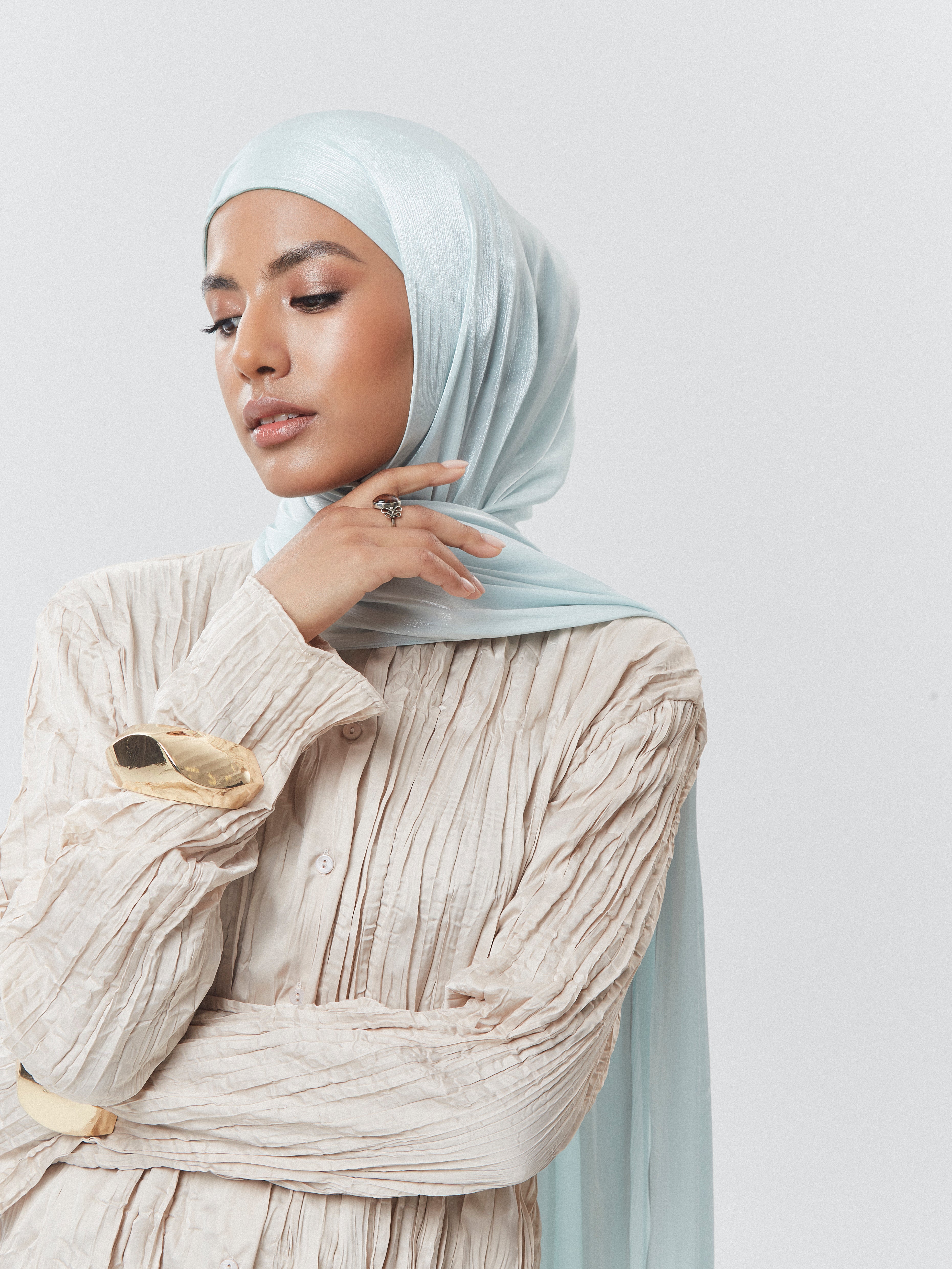 Elegant woman wearing Yovlaq’s mint cream silk chiffon hijab styled with a cream pleated blouse – luxury modest fashion for modern women.